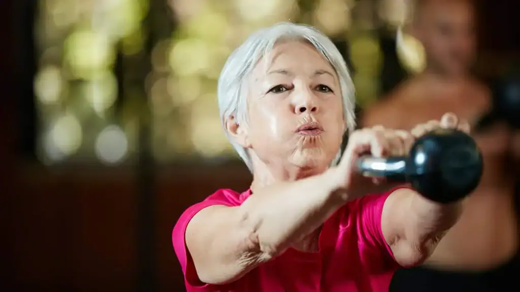Older woman doing weight training Maplehurst to help her strength and longevity 