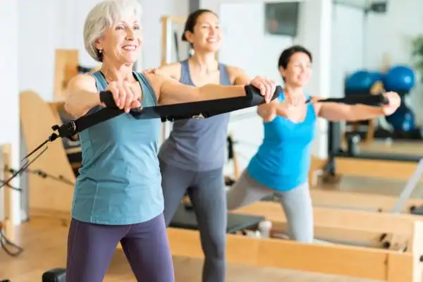 Toning Arms After 60: Empowering Womens Fitness Through Effective Weight Training 2 older woman doing weight training Maplehurst and resistance in the gym to tone upper arms