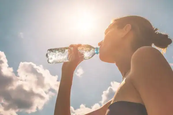 Hydration: The Secret Ingredient for a Toned Stomach and Enhanced Fitness 3 Image of woman drinking water to hydrate Maplehurst after run.